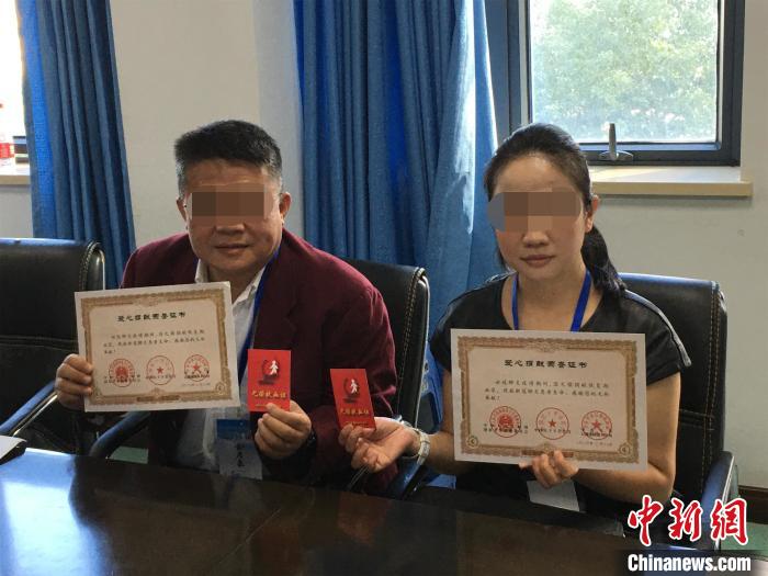 金先生和妻子展示捐赠血浆证书 马芙蓉 摄