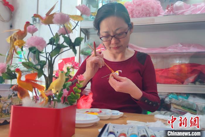 曹淑贞的女儿李静咏是泉州彩扎项目市级传承人。图为李静咏在为“凤凰”涂色。　吴冠标 摄