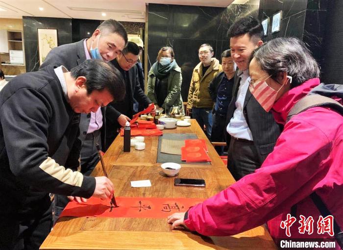 图为书法家赠送春联。　张莉娜 摄