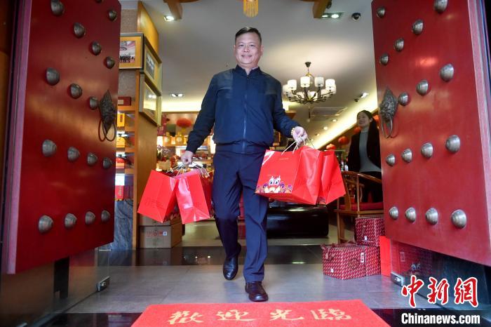 图为李尚儒为顾客送茶叶。　吕明 摄