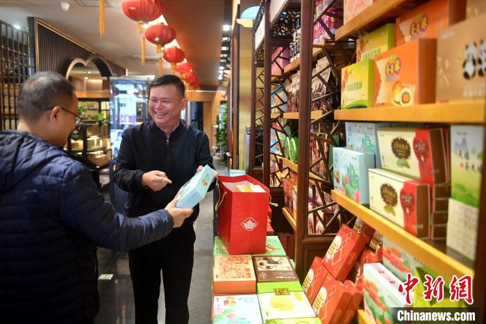 图为李尚儒为顾客介绍茶叶、茶点。　吕明 摄
