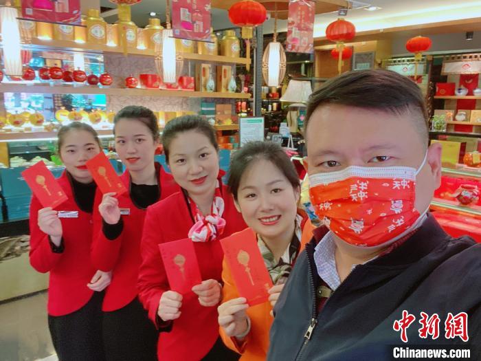 天福茗茶福州分公司台籍总经理李尚儒(右一)和来自漳州的太太陈淑娟(右二)，初一一大早就到各个门店给留守的同事们派发慰问红包。 受访者提供