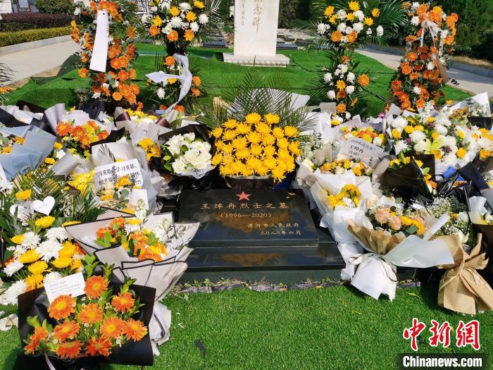 烈士王焯冉的墓碑旁边放满了鲜花。　王登峰 摄