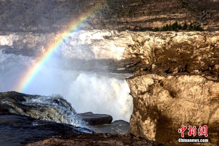 壶口瀑布巨冰伴彩虹吸引游客观赏