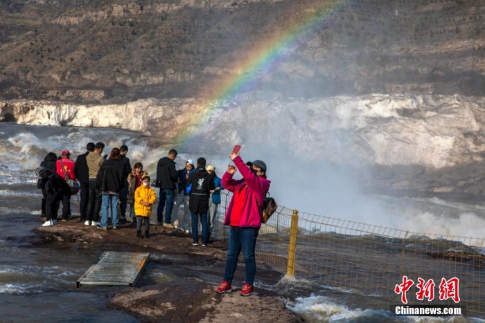 壶口瀑布巨冰伴彩虹吸引游客观赏