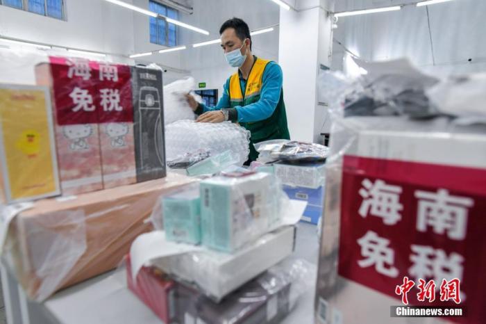 中国邮政集团公司海口市分公司的工作人员正在打包需要“邮寄送达”服务的海南离岛免税品。
<a target='_blank' href='http://www.chinanews.com/'>中新社</a>记者 骆云飞 摄