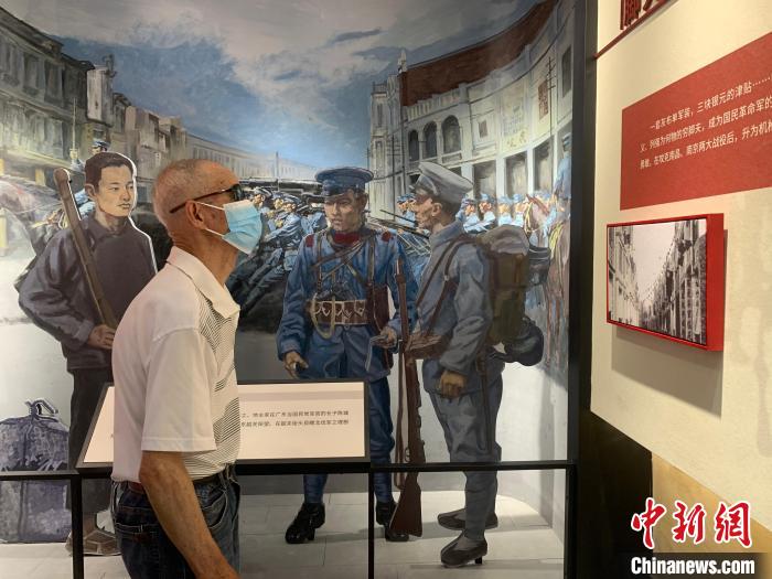 一位老人仔细参观展览。　郭其钰 摄