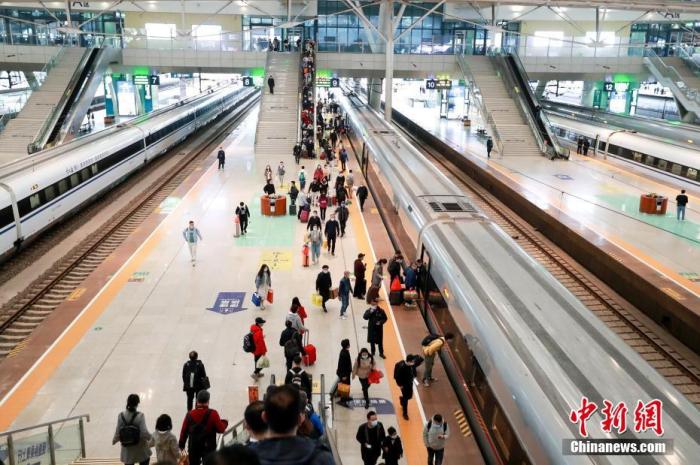 资料图：旅客在武汉火车站站台准备乘坐高铁列车。 图片来源：视觉中国