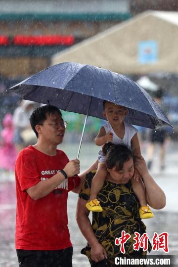 市民冒雨前行。　泱波 摄