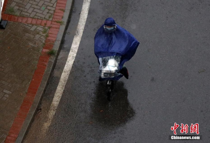 北京遇今年汛期最强降雨 市民冒雨出行