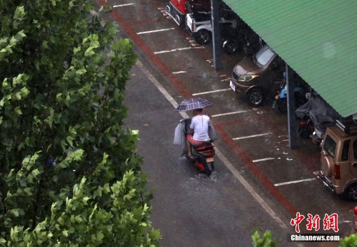 北京遇今年汛期最强降雨 市民冒雨出行