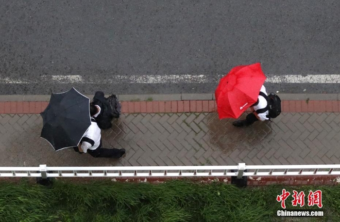 北京遇今年汛期最强降雨 市民冒雨出行