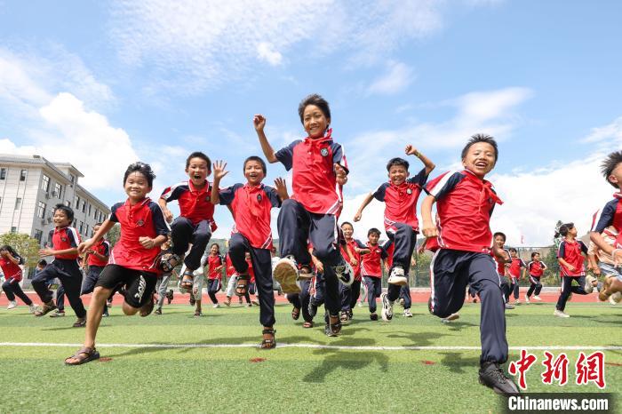 图为大歹小学学生在学校足球场奔跑。　瞿宏伦 摄