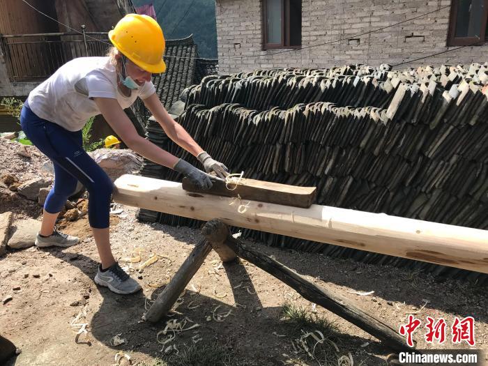 图为外国志愿者做木工，参与老屋修复。　受访者供图