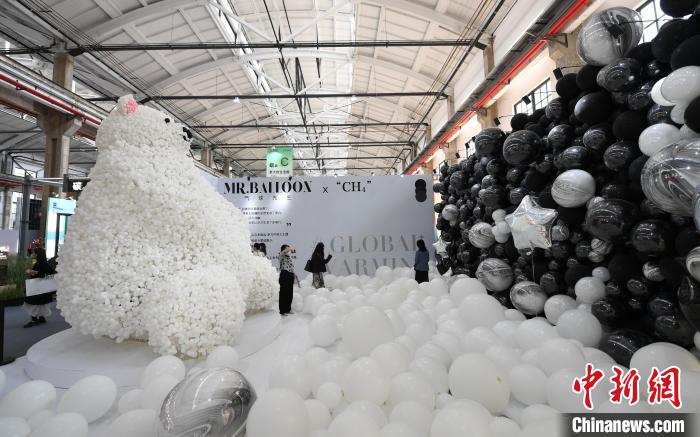 图为：以可降解材质气球营造的“冰川融化”“北极熊”“黑色污染”等装置吸引参观者拍照。　王刚 摄