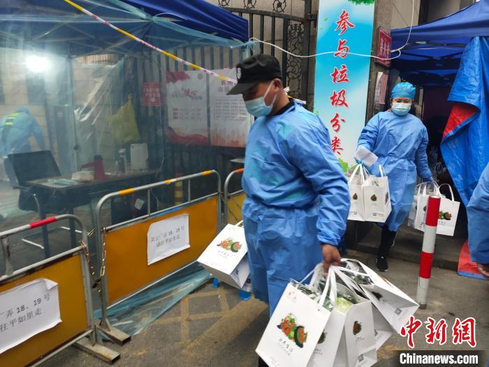 杭州一封闭管理小区，工作人员为居民配送爱心蔬菜。　王逸飞 摄