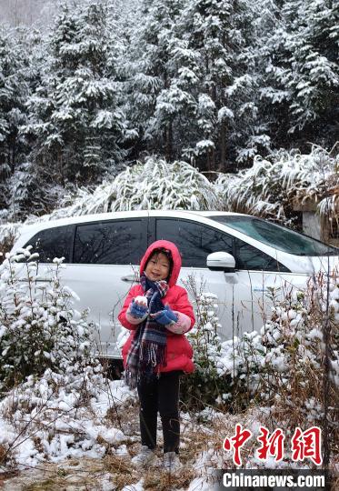 图为：浙江金华一名小朋友在山林中玩雪。　张赛(通讯员) 摄