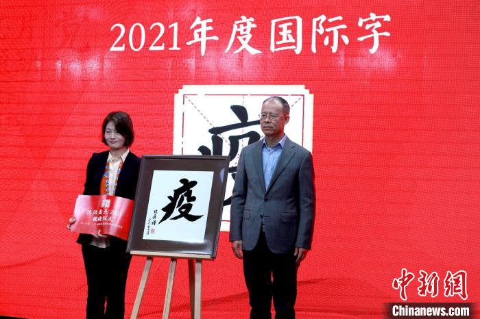 嘉宾现场揭晓“汉语盘点2021”年度国际字“疫” 商务印书馆供图    图片来源：中新网