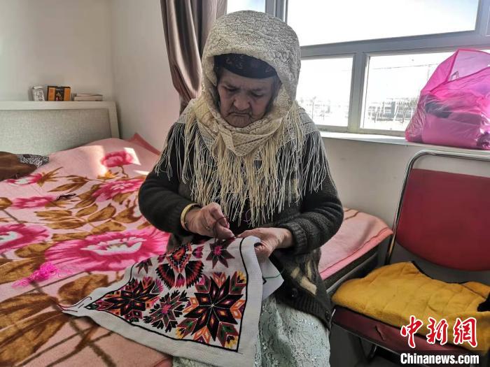 老人在房间里刺绣。　朱景朝 摄