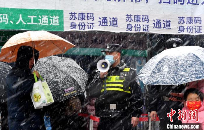 7日上午，南京公安干警冒雪值守在人流量较大的地区，保障行人安全。　国武 摄