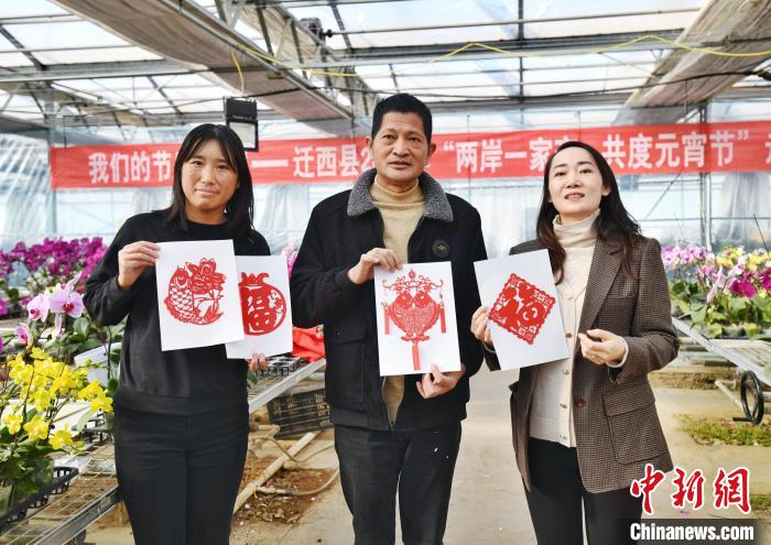 台商景文德(中)展示迁西非遗剪纸作品。　赵亮 摄