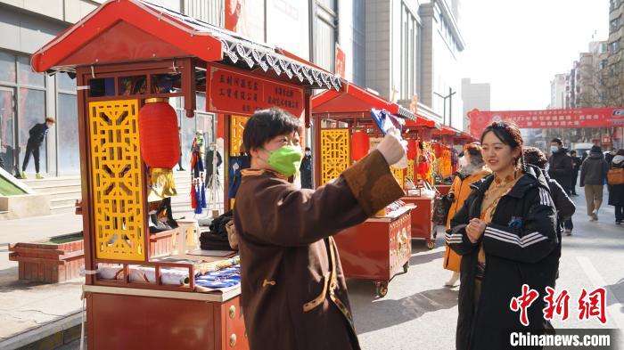 图为市民正在非遗工艺品展销柜前拍照。　潘雨洁 摄