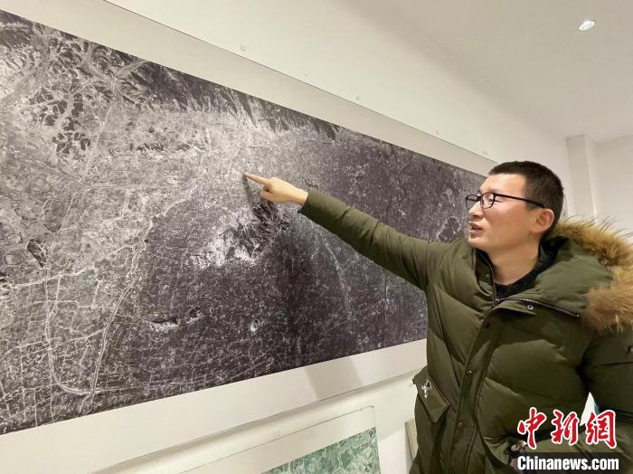 姬翔介绍卫星图上的良渚古城。　童笑雨 摄