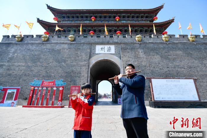 3月14日，韩国峰正在与自己的儿子一起演奏竹笛。　赵亮 摄