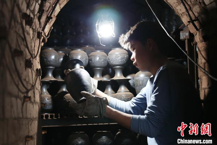 图为馆陶县一家黑陶制品厂工人正在检查刚出窑的黑陶。　郭江鹏 摄
