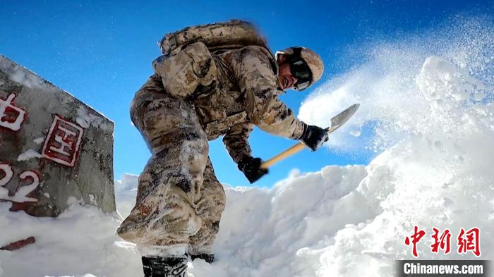 图为巡逻官兵清理界碑积雪。　西藏军区供图