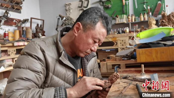 木雕是刀尖下的艺术，凝固手工之魂。图为木雕艺人王全胜正在创作。　王惠琳 摄