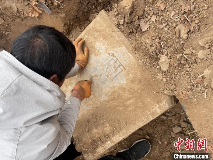 图为文物工作人员在对石碑进行考古挖掘。　孙媛媛 摄