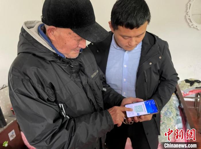 工作人员指导朱家翼使用“健康码” 章雪瑶 摄