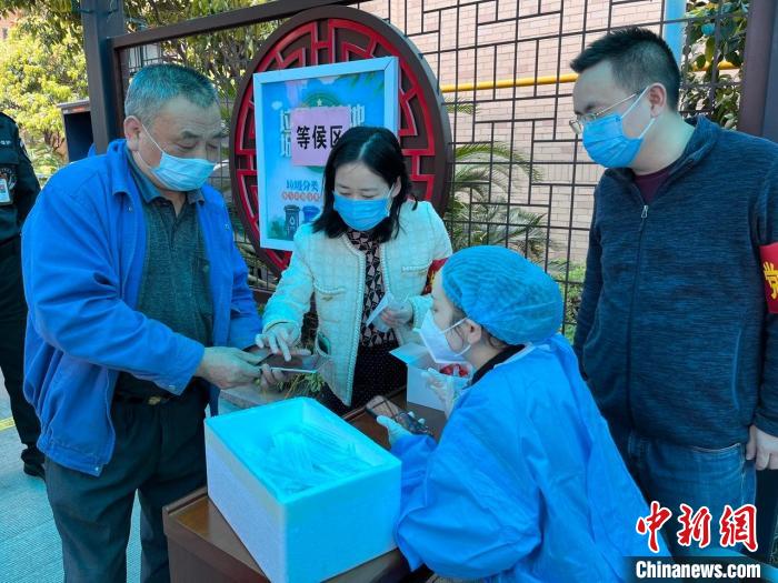 湖南省税务局青年党员主动参与雨花区全员核酸检测志愿者工作，引导社区居民扫码检测。　罗舜爱 摄