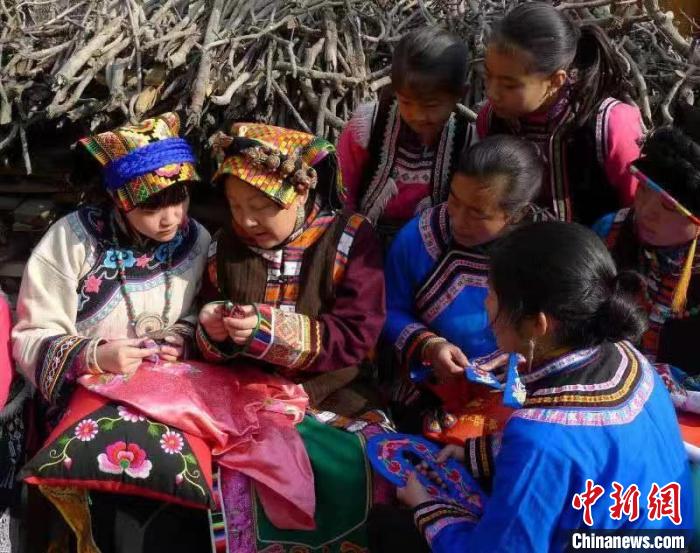 杨华珍(左二)为乡村绣娘开展刺绣培训。　受访者供图