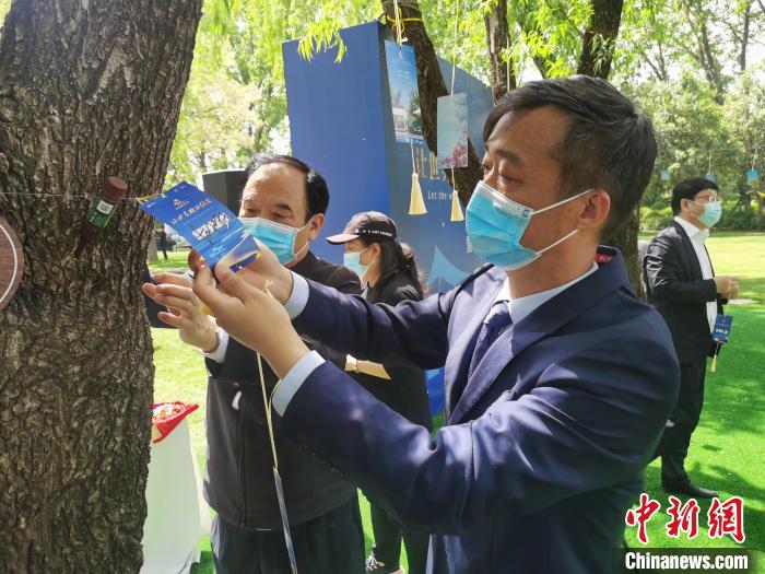 与会嘉宾将诗意卡片挂上树枝。　刘鹏 摄