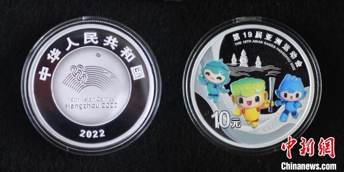 图为：30克圆形银质纪念币正面为第19届亚运会会徽并刊国名、年号，背面为第19届亚运会吉祥物。　王刚 摄