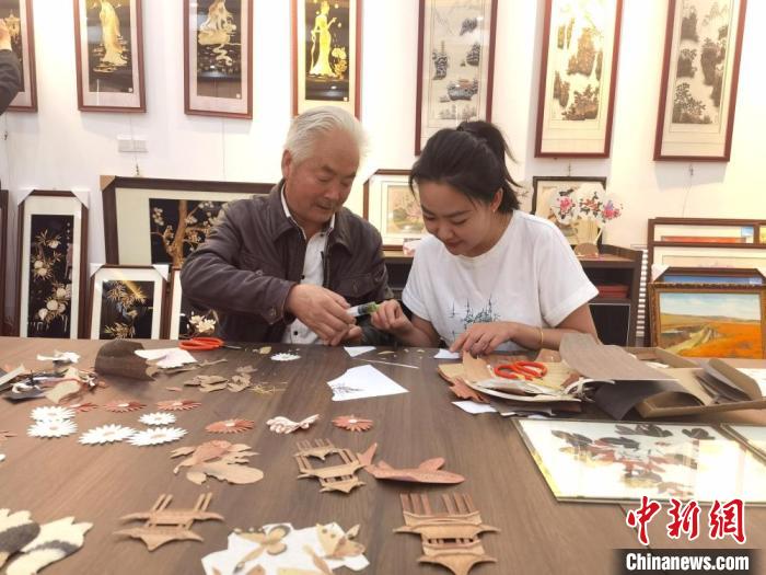 木塑画制作技艺市级非遗传承人苏永生(左)教授制作木塑画。　闫姣 摄