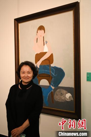 图为广东省女画家协会主席孙洪敏与自己的作品《猫·女孩》合影 陈楚红 摄