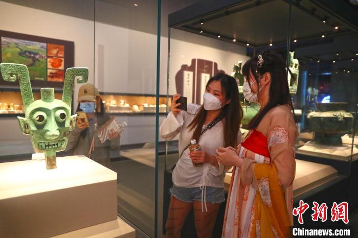 图为江西省博物馆讲解员巫悦(右)身穿汉服为观众讲解江西省博物馆镇馆之宝之一的商代双面神人青铜头像。　刘占昆 摄