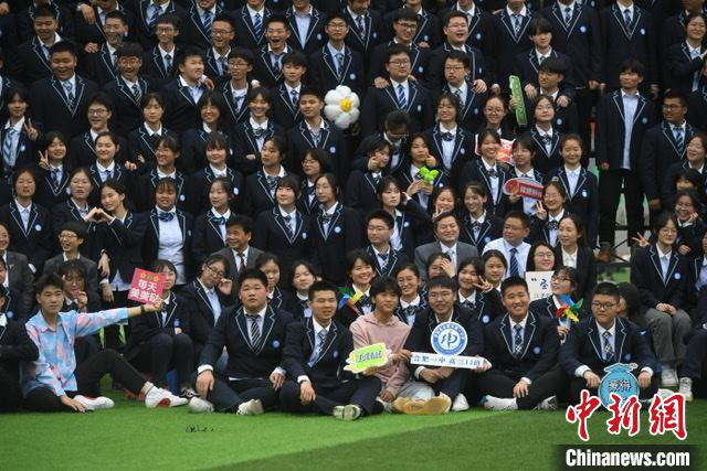 学生们在拍摄毕业照时展示创意标语。　韩苏原 摄