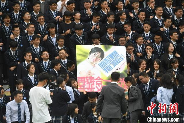 学生们在拍摄毕业照时展示创意标语。　韩苏原 摄