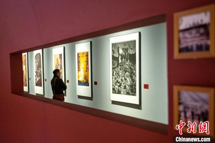 展厅内一名参观者正在仔细观看作品《攀钢·火红的年代》。　刘忠俊 摄
