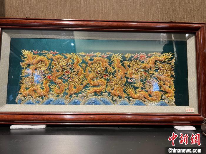 《九龙壁》构图饱满，用金线绣制，看起来金碧辉煌。　方伟彬 摄