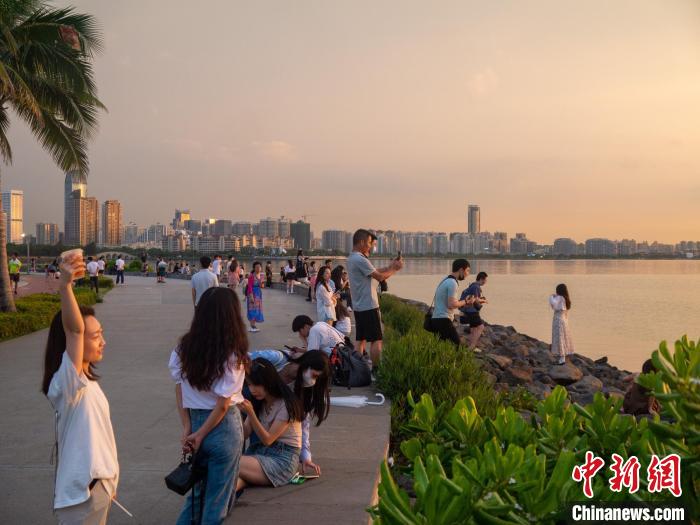 在海边拍摄夕阳美景的游客。　凌楠 摄