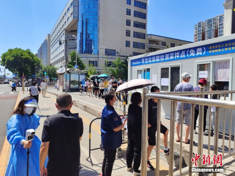 北京市民在街头常态化核酸检测采样点参加检测