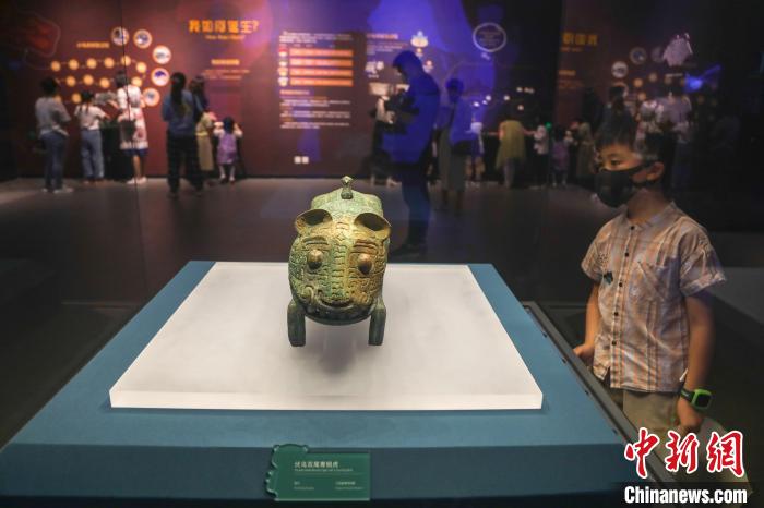 图为一位儿童在观看展出的江西省博物馆“镇馆之宝”之一的伏鸟双尾青铜虎。　刘力鑫 摄