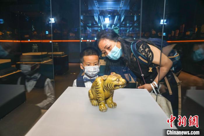 图为一位儿童在家长的陪伴下观看展出的清代黄釉虎。　刘力鑫 摄