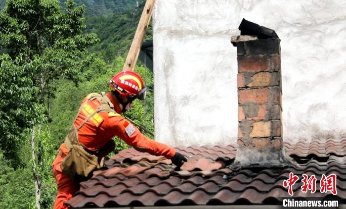 森林消防員幫助修補受損的屋頂。　曾鵬 攝