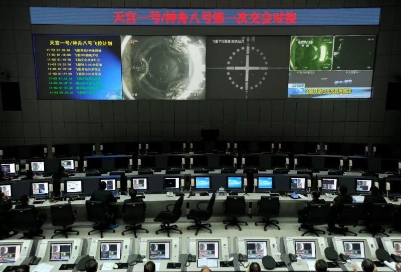 2011年11月3日凌晨，在酒泉卫星发射中心指控大厅，技术人员通过大屏幕观看天宫一号与神舟八号飞船对接全程。（图源：央视新闻）